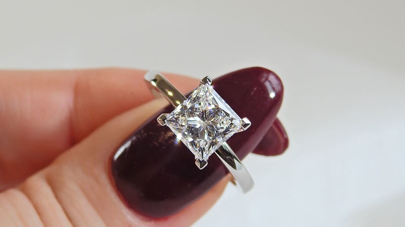 Hand Holding Princess Cut Solitaire Engagement Ring