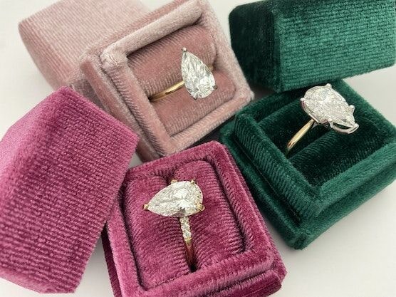 Pear diamond rings on velvet boxes.