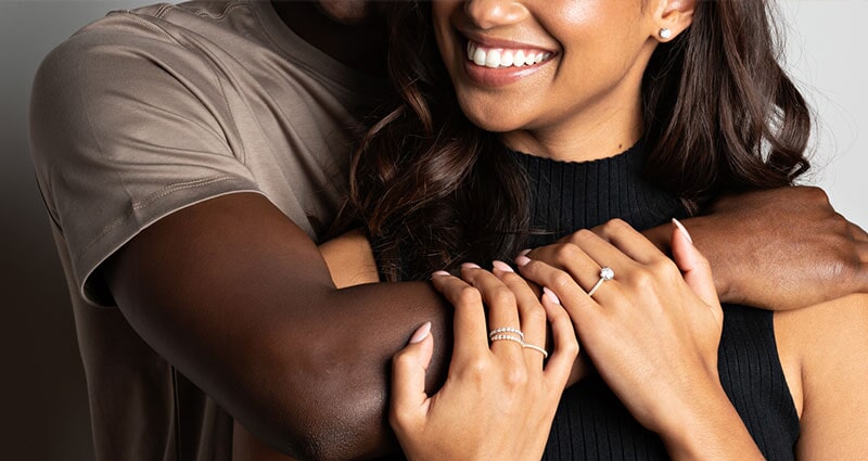 Couple hugging and shopping for a diamond ring together