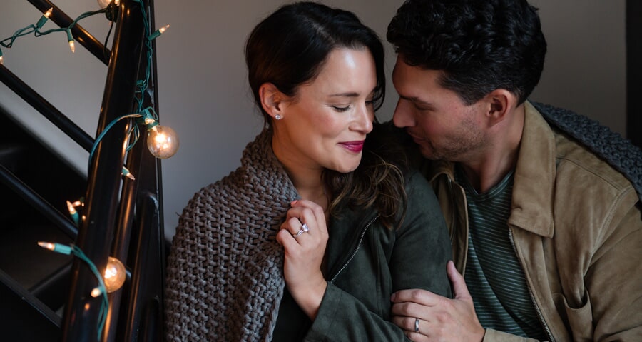 Cozy couple snuggling under a blanket in fall 